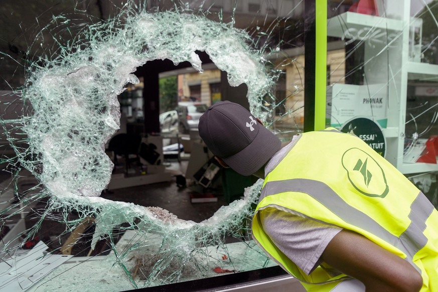epaselect epa10720363 A person inspects a damaged shop window following a night of looting and rioting in Montreuil, near Paris, France, 01 July 2023. Violence broke out across France over the fatal s ...