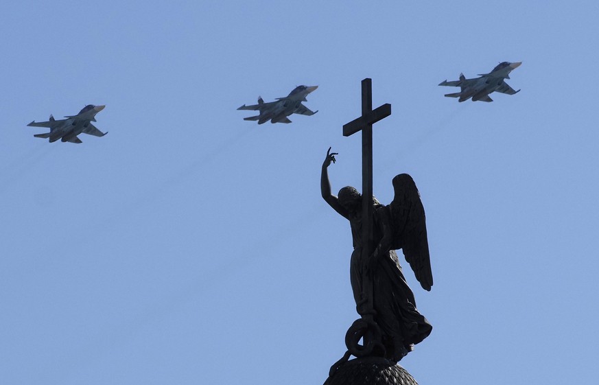 Sukhoi Su-34 fighter-bomber jets fly over a statue of an angel fixed atop the Alexander Column during the Victory Day military parade at Dvortsovaya (Palace) Square in St. Petersburg, Russia, Sunday,  ...