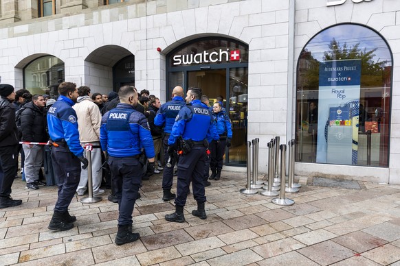 Swiss police officers secure the area where customers queue to buy the new Royal Pop watch by Swatch and Audemars Piguet, in Geneva, Switzerland, Saturday, May 16, 2026. The collection of eight Royal  ...