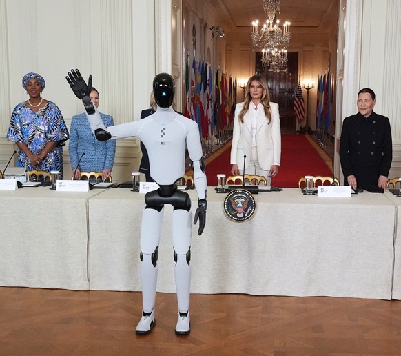 First lady Melania Trump arrives, accompanied by a robot, to attend the "Fostering the Future Together Global Coalition Summit," with other first spouses, at the White House, Wednesday, Marc ...