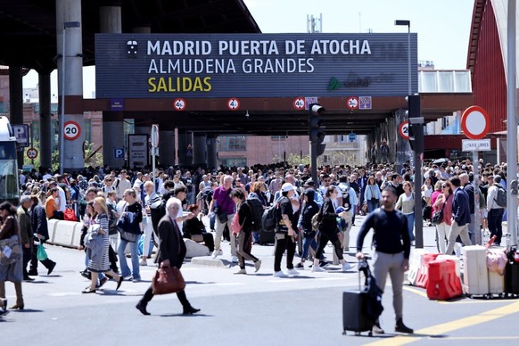 People leave the Atocha train station in Madrid after its closure as a massive power outage hits Spain on April 28, 2025. Power went out across all of Spain and Portugal today, cutting cellphone and i ...
