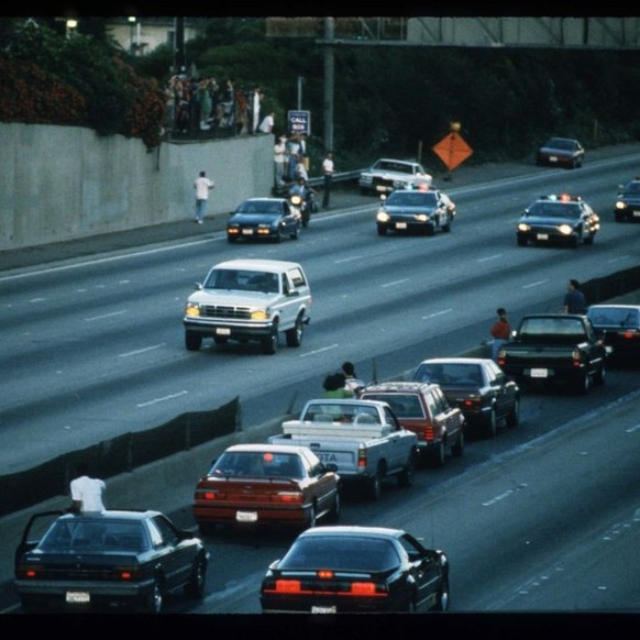 LOS ANGELES - JUNE 17: Motorists stop and wave as police cars pursue the Ford Bronco (white, R) driven by Al Cowlings, carrying fugitive murder suspect O.J. Simpson, on a 90-minute slow-speed car chas ...