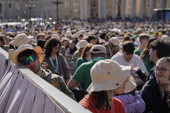 A young man rests as youths gather for a mass presided by Vatican Secretary of State, Cardinal Pietro Parolin, on the second of nine days of mourning for late Pope Francis, in St. Peter&#039;s Square, ...