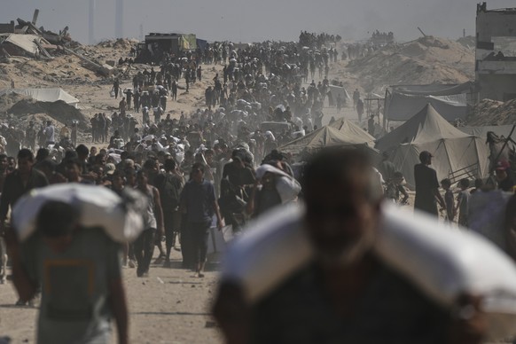 Palestinians carry sacks of flour unloaded from a humanitarian aid convoy on the outskirts of Beit Lahiya, northern Gaza Strip, Saturday, Aug. 23, 2025. (AP Photo/Abdel Kareem Hana)
Israel Palestinian ...