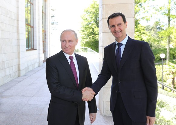 epa06745631 Russian President Vladimir Putin (L) shakes hands with Syrian President Bashar al-Assad (R) during their meeting in the Black sea resort of Sochi, Russia, 17 May 2018. During the meeting t ...