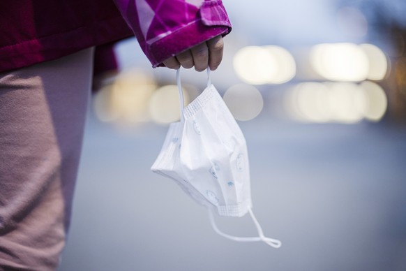 Eine Primarschuelerin haelt eine Kinder Maske auf einem Pausenplatz einer Schule, aufgenommen am Montag, 3. Januar 2022 in Zuerich. Die Maskentragpflicht im Kanton Zuerich wird mit dem Schulstart nach ...