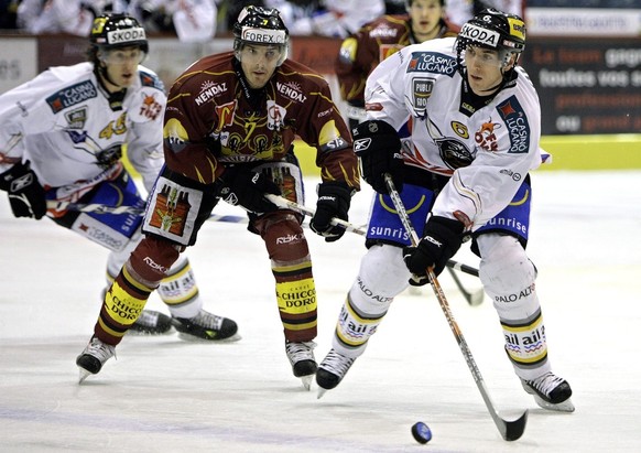 Le joueur Tessinois Wesley Snell, droite, a la lutte pour le puck avec le joueur Genevois Jan Cadieux, gauche, lors du match du championnat suisse de hockey sur glace LNA, entre le HC Geneve Servette  ...