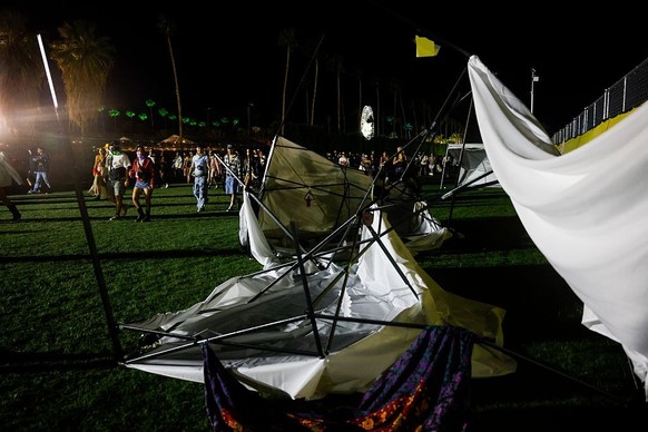INDIO, CA - APRIL 10, 2026: Festival goers walk past tents blown down by the wind during the Coachella Valley Music and Arts Festival at the Empire Polo Club on Friday, April 10, 2026, in Indio, CA. ( ...