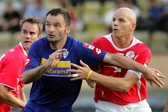 Le Lausannois Stephane Chapuisat, centre, lutte, entre les joueurs du FC Winterthur Pascal Renfer, gauche, et Umberto Romano, lors du premier match de la saison 2005-2006 du championnat suisse de foot ...