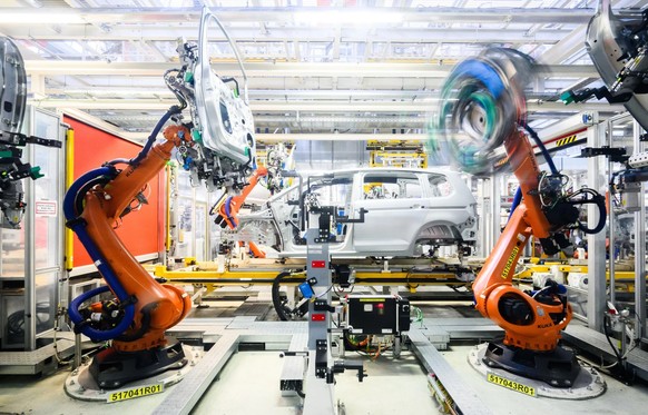 Des robots montent les portières d'une voiture neuve.