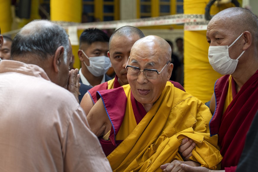 FILE- Tibetan spiritual leader the Dalai Lama greets a guest as he leaves after attending a special event during which exile Tibetans made him traditional offerings and prayed for his long life, at th ...