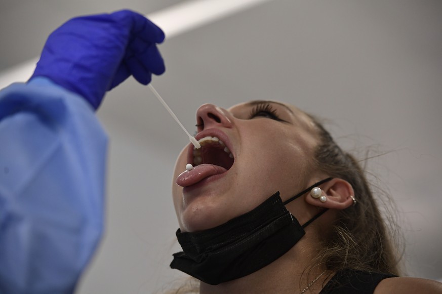 A health worker takes a swab from a teenager during a rapid antigen test for COVID-19 in Pamplona, northern Spain, Sunday, July 4, 2021. Local authorities have called on teenagers to be tested due to  ...