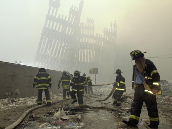 Firefighters work beneath the destroyed mullions, the vertical struts which once faced the soaring outer walls of the World Trade Center towers, after a terrorist attack on the twin towers of lower Ma ...