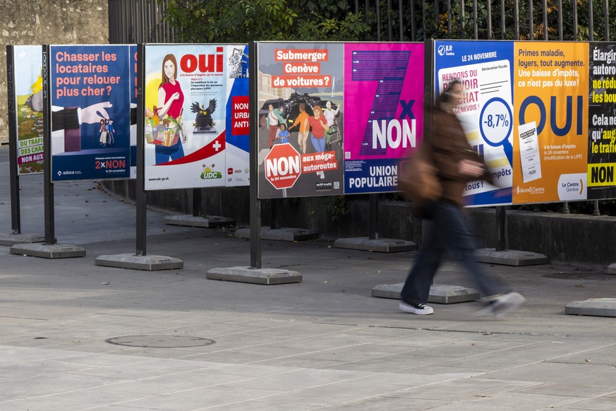 Une personne passe vers les affiches des partis politiques et des associations donnant leurs mots d&#039;ordre pour les votations federales et cantonales du 24 novembre, ce dimanche 10 novembre 2024 a ...