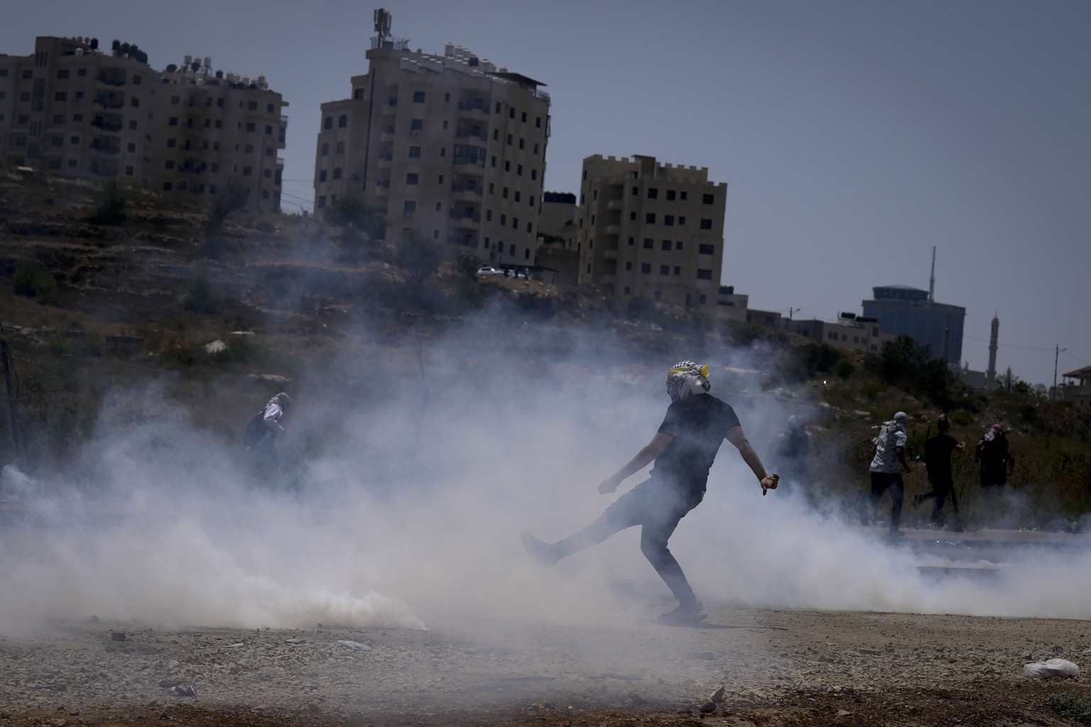 Palestinian protesters run away from tear gas during clashes with Israeli forces following a demonstration against Israel&#039;s airstrikes on Gaza Strip, near the West Bank Jewish settlement of Beit  ...