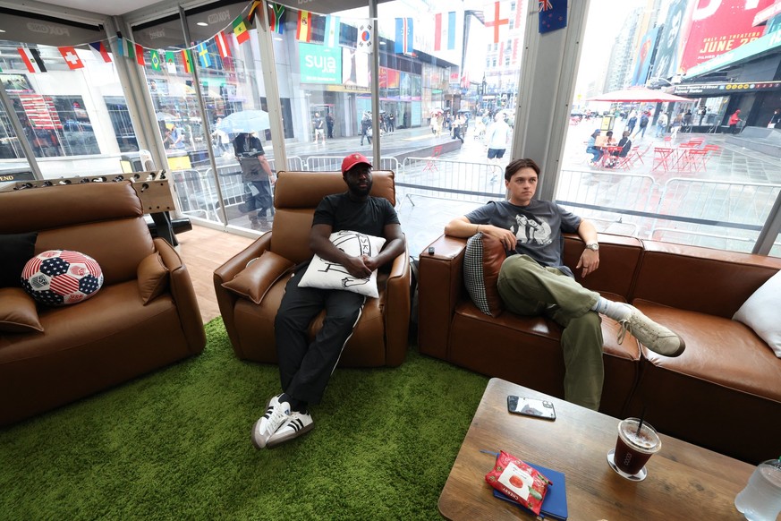 Austin Franklin (right) and Kevin Akoto watch a 2026 World Cup match between Portugal and Uzbekistan from their transparent cube in Times Square in New York, on June 23, 2026. The pair being paid $50, ...