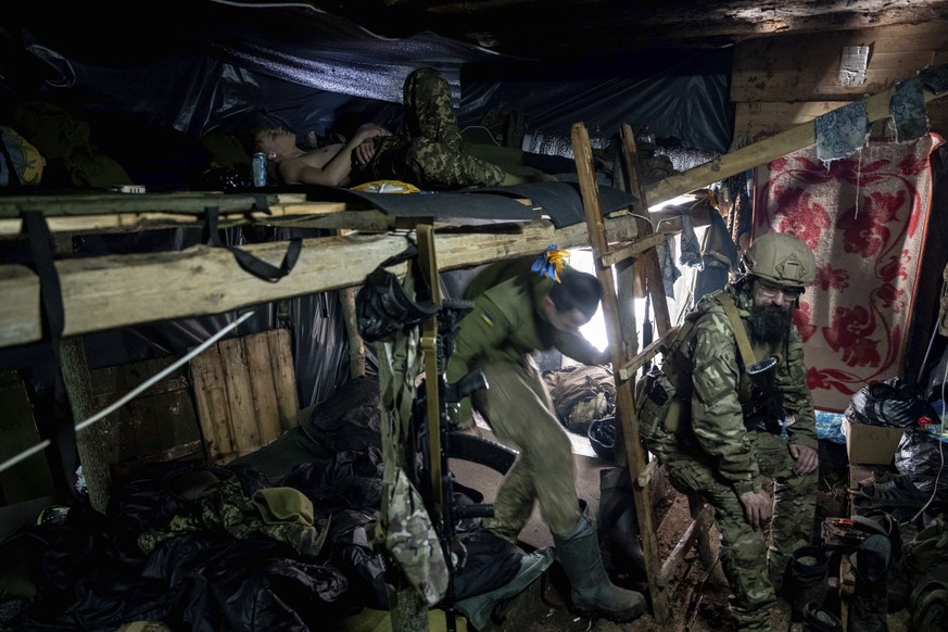 Ukrainian paratroopers of 80 Air Assault brigade rest inside a dugout at the frontline near Bakhmut, Ukraine, Friday, March 10, 2023. (AP Photo/Evgeniy Maloletka)