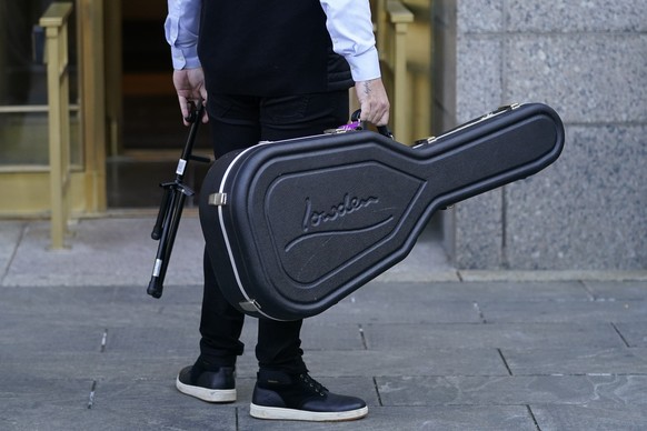 Un membre de l'entourage de l'artiste Ed Sheeran portant un étui de guitare avant que l'artiste ne quitte le tribunal fédéral de New York, dans son procès pour violation de droits d'auteur, le 26 avri ...