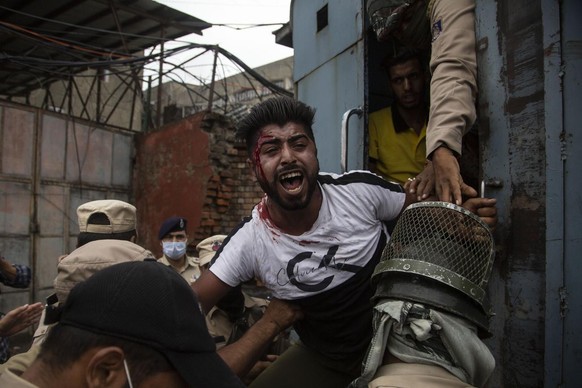 Indian policemen detain a Kashmiri Shiite Muslim as he attempt with others to take out a religious procession in Srinagar, Indian controlled Kashmir, Friday, Aug. 28, 2020. Police and paramilitary sol ...