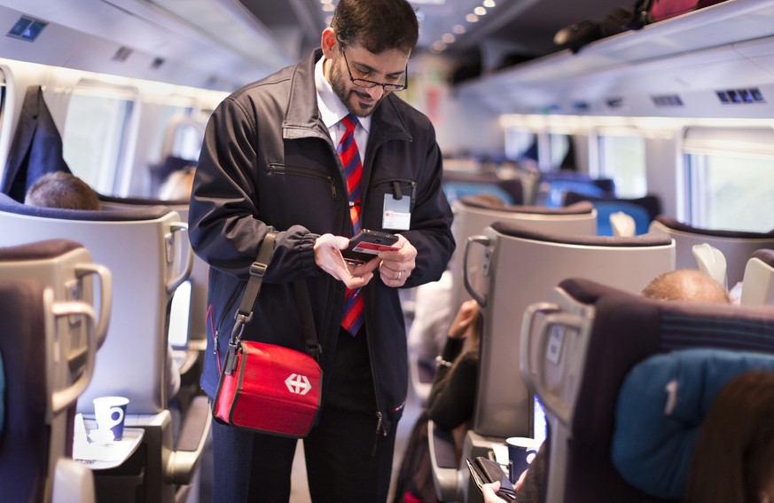 ZUR EINFUEHRUNG DES SWISSPASSES VOR DREI MONATEN STELLEN WIR IHNEN HEUTE, MITTWOCH, 4. NOVEMBER 2015, FOLGENDES NEUES BILDMATERIAL ZUR VERFUEGUNG --- Conductor Salvatore Grade verifies a train passeng ...