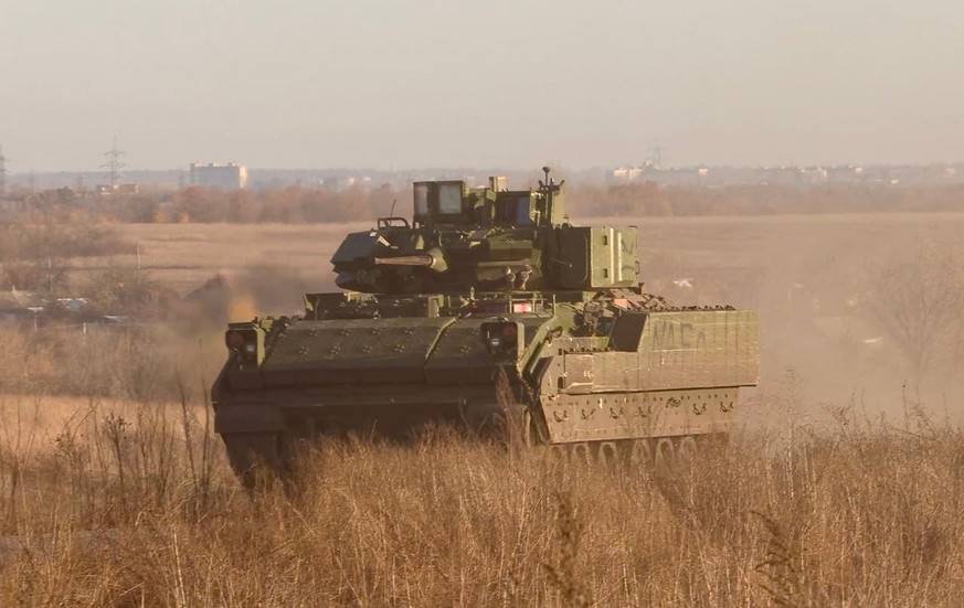 Un véhicule de combat d'infanterie américain Bradley revient du front. Avdiïvka est visible à l'arrière-plan.