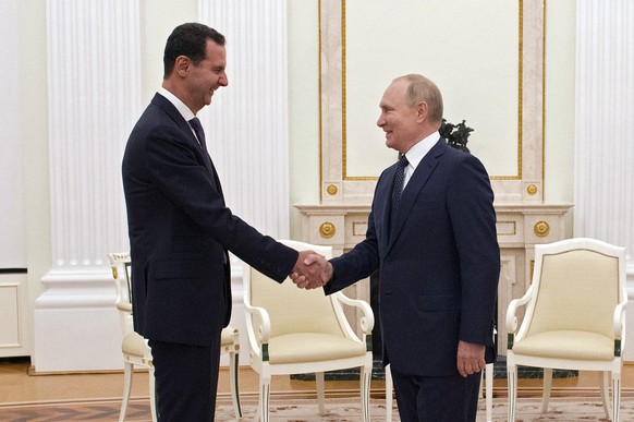 epa09466987 Russian President Vladimir Putin (R) shakes hands with Syrian President Bashar al-Assad (L) during their meeting in Moscow, Russia, 13 September 2021 (issued 14 September 2021). EPA/MIKHAE ...