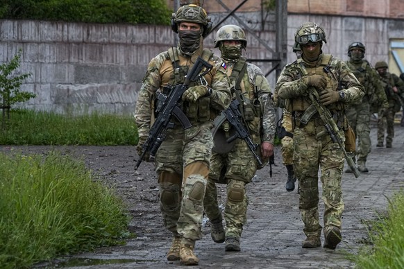 Russian troops walk at a destroyed part of the Illich Iron &amp; Steel Works Metallurgical Plant in Mariupol, in territory under the government of the Donetsk People&#039;s Republic, eastern Ukraine,  ...