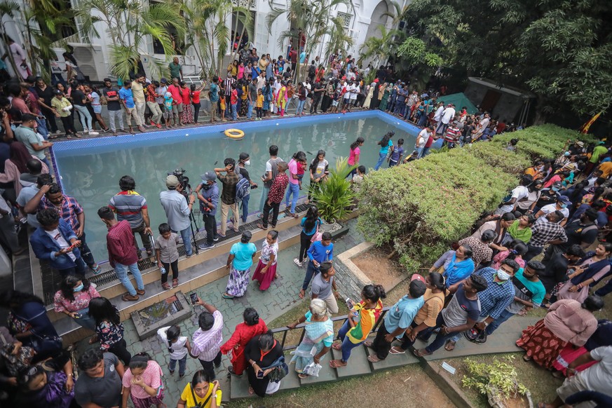 epa10063865 People take a look at and a dip in a swimming pool at the President&#039;s palace in Colombo, Sri Lanka, 10 July 2022, a day after official residences were stormed. Sri Lankan president an ...