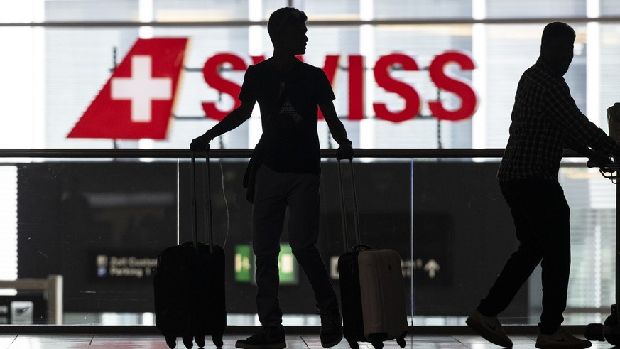 Menschen warten am Flughafen auf ihren Abflug in die Ferien, aufgenommen am Freitag, 8. Juli 2022 auf dem Flughafen in Zuerich. (KEYSTONE/Ennio Leanza)