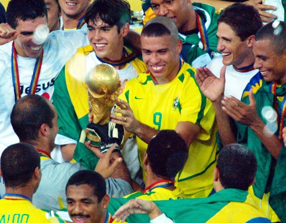 Brazil&#039;s Ronaldo, center, holds the World Cup trophy as he celebrates the 2002 World Cup final victory with teammates in Yokohama, Japan, Sunday, June 30, 2002. Brazil defeated Germany 2-0 with b ...