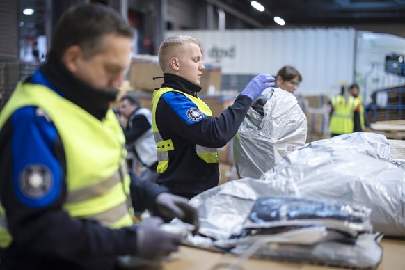 Mitarbeiter des Bundesamts fuer Zoll und Grenzsicherheit (BAZG) oeffnen Pakete waehrend einer Schwerpunktkontrolle im grenzueberschreitenden Online-Handel des Bundesamts fuer Zoll und Grenzsicherheit  ...