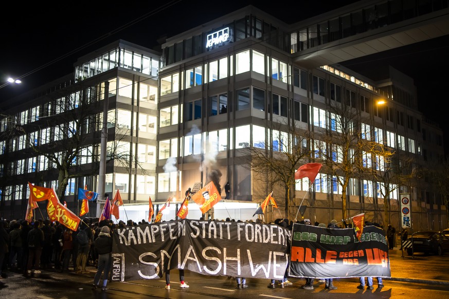 Protesters hold a banner reading &quot;Smash WEF&quot; during a demonstration against the World Economic Forum (WEF) in front of a KPMG building on Tuesday, January 17, 2023 in Zurich, Switzerland. Th ...