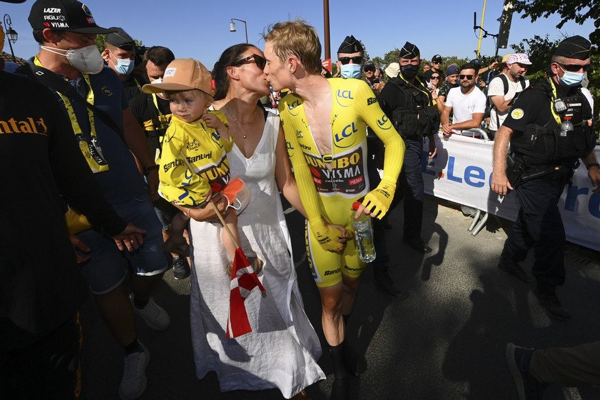 Denmark&#039;s Jonas Vingegaard, wearing the overall leader&#039;s yellow jersey, kisses his wife Trine Hansen, who is holding their child Frida, s they celebrate after the twentieth stage of the Tour ...