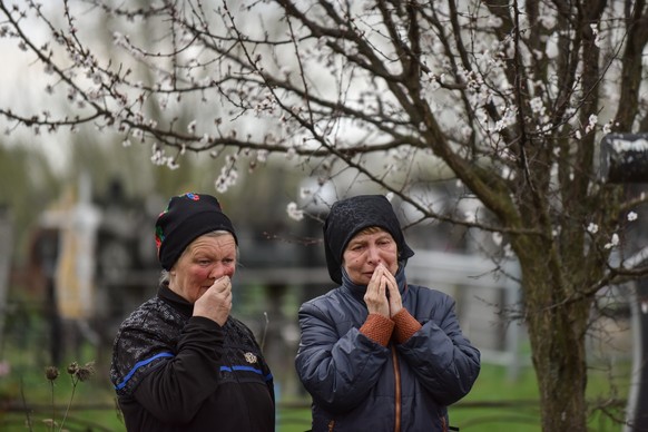 epa09908480 Woman cry during a funeral ceremony of Yurii Krasnozhon, who was killed in basement of postal office where he was inprisoned by Russian soldiers together with other several men, at the cem ...