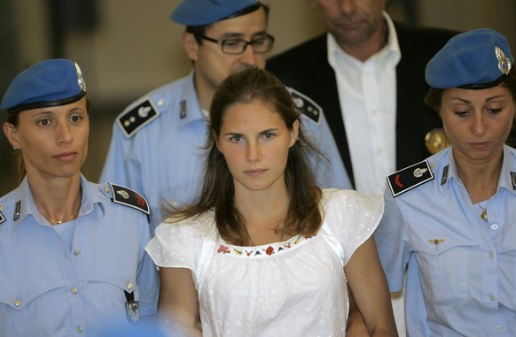 Amanda Knox, center, an American student suspected in the slaying of her British roommate, is escorted by Italian penitentiary police officers from court following a hearing, in Perugia, central Italy ...