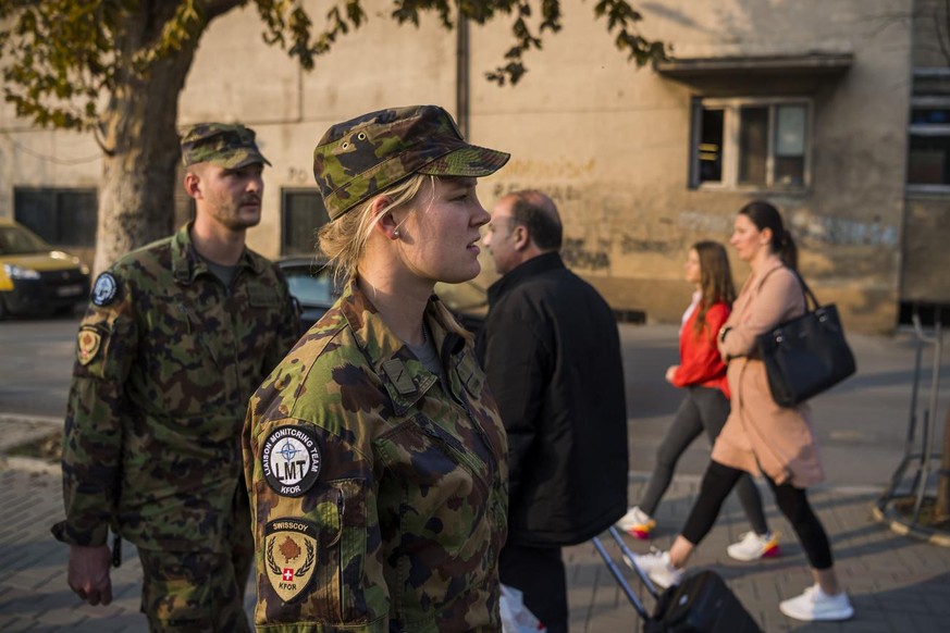 Le Lieutenant Mirko Della Pietra et la soldate Rea Tanner, membres d&#039;une equipe de liaison et de surveillance, LMT, (Liaison and Monitoring Teams) marchent dans les rues de la ville pour discuter ...