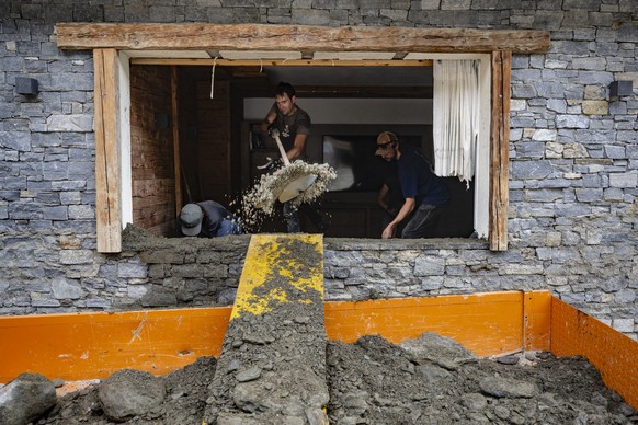 Des villageois enlevent des gravats a l&#039;interieur d&#039;une salle de l&#039;Hotel Eden dans le village haut-valaisan ensevelie ce week-end par une lave torrentielle le mardi 2 juillet 2024 a Saa ...
