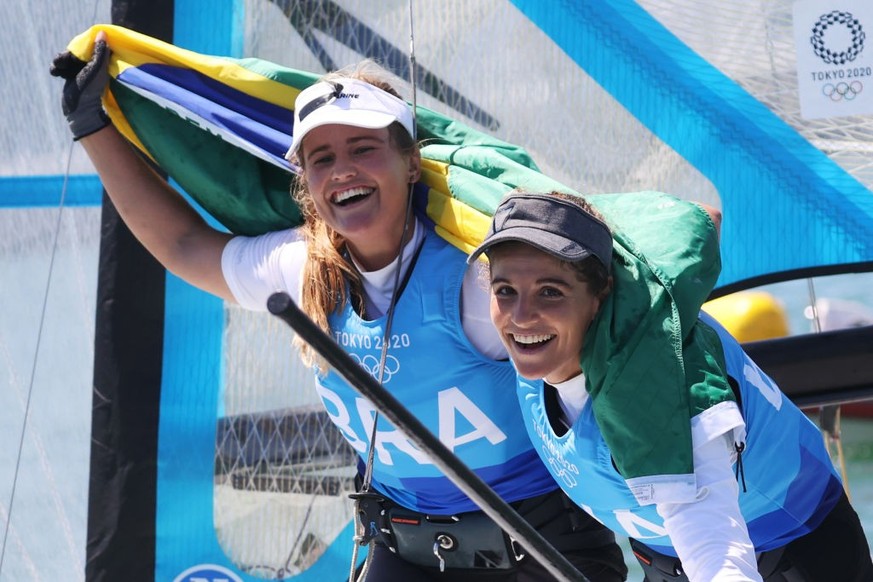 FUJISAWA, JAPAN - AUGUST 03: Martine Grael (r) and Kahena Kunze of Team Brazil celebrate winning gold in the Women&#039;s Skiff 49er class on day eleven of the Tokyo 2020 Olympic Games at Enoshima Yac ...