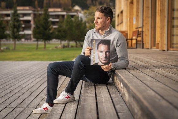 Der ehemalige Langlaeufer Dario Cologna posiert mit seinem Buch von Herausgeber Peter Roethlisberger, am Dienstag, 1. November 2022, in Davos. (KEYSTONE/Yanik Buerkli)