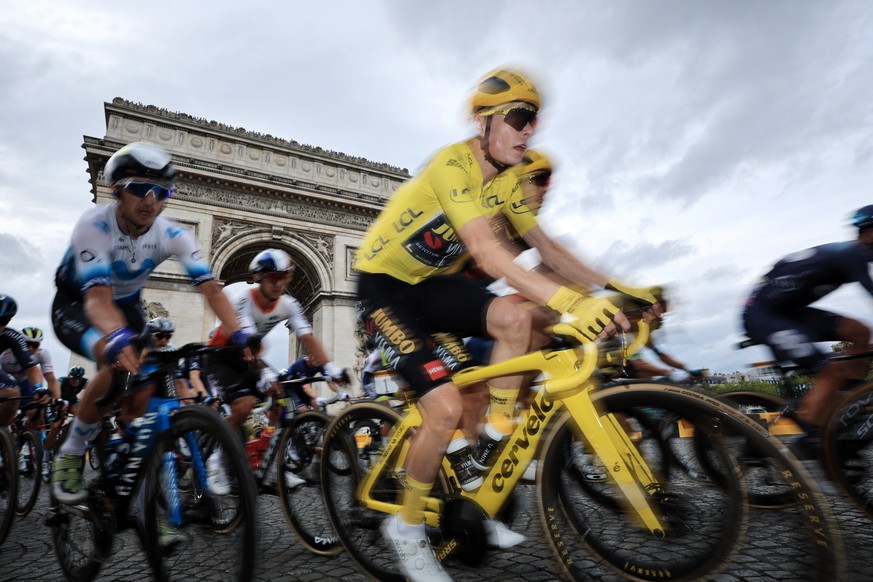 epa10764630 Yellow Jersey overall leader Danish rider Jonas Vingegaard of team Jumbo-Visma ride past the Arc de Triomphe during the 21st and final stage of the Tour de France 2023 over 115kms from Sai ...