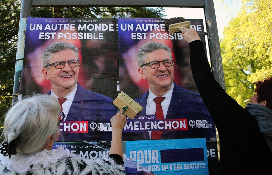 Supporters of of far-left leader Jean-Luc Melenchon glue a campaign poster in Hendaye, southwestern France, Thursday, April 7, 2022. The two-round presidential election will take place on April 10 and ...