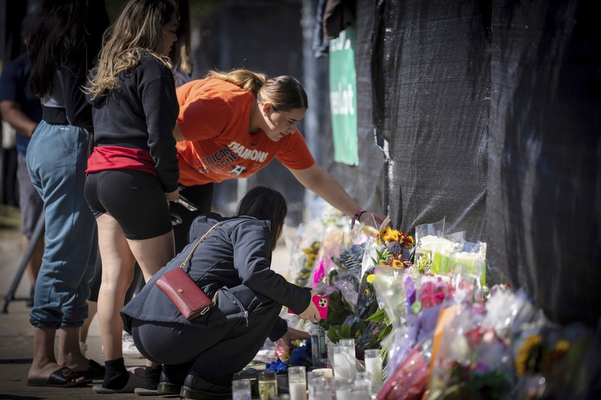 Stacey Sarmiento places flowers at a memorial in Houston on Sunday, Nov. 7, 2021 in memory of her friend, Rudy Pena, who died in a crush of people at the Astroworld music festival on Friday. (AP Photo ...