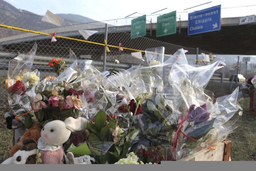 Flowers and soft toys are seen near the tunnel, where a tourist bus from Belgium crashed in a tunnel of the motorway A9, in Sierre, western Switzerland, Saturday, March 17, 2012. Last Tuesday, twenty- ...