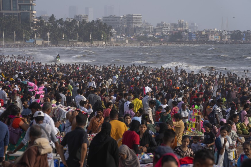 People crowd the Juhu beach on the Arabian Sea coast on a hot and humid day in Mumbai, India, Sunday, May 8, 2022. (AP Photo/Rafiq Maqbool)
