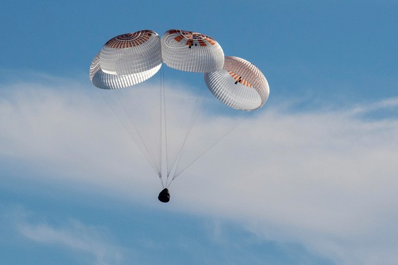 In this image provided by NASA, a SpaceX capsule floats over the Gulf of Mexico, Tuesday, March 18, 2025, as it lands off the coast of Florida with NASA astronauts Suni Williams, Butch Wilmore and Nic ...