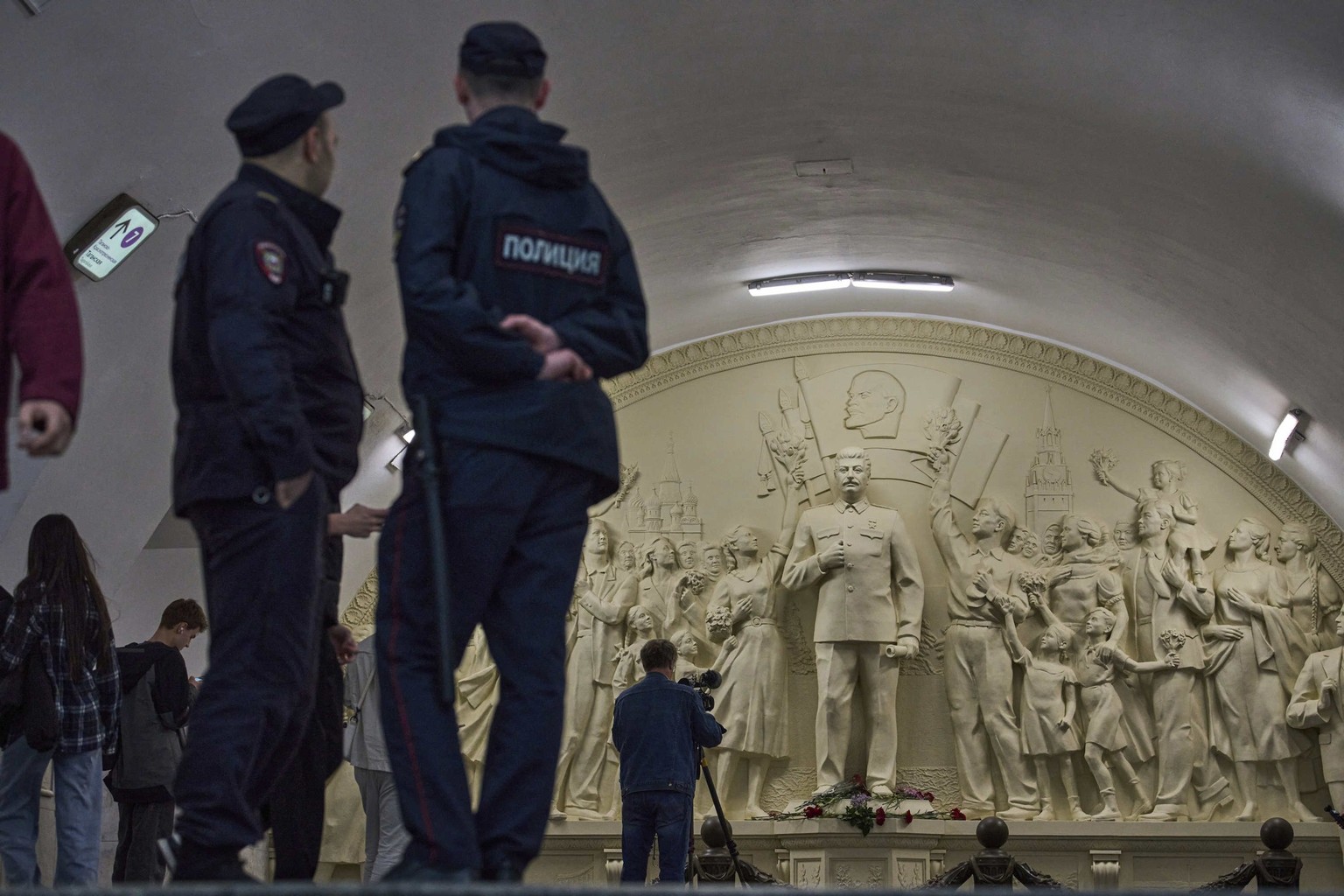Police officers stand at the passage between stations as a cameraman films a restored 1960 High relief &quot;The Gratitude of the People to Leader-Commander&quot; depicting Soviet leader Joseph Stalin ...