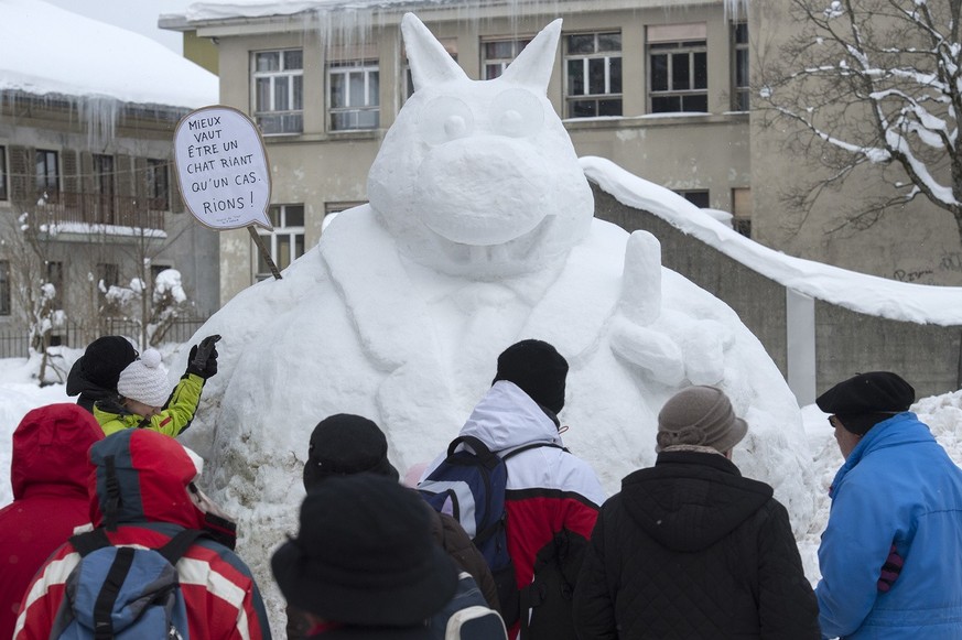 People look at a snow sculpture that is part of Imagineige, a snow sculpture and buildings contest festival, in La Chaux-de-Fonds, Switzerland, Sunday, February 8, 2015. (KEYSTONE/Sandro Campardo)