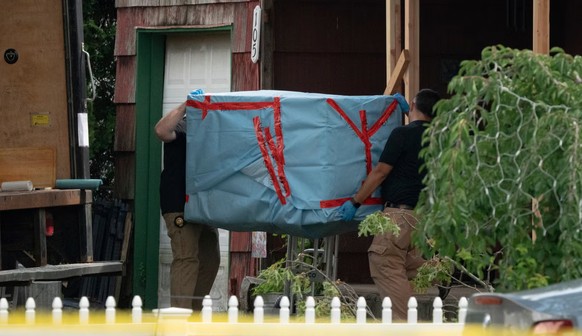 Les enquêteurs en pleine perquisition du domicile de la famille, où une glacière a notamment été récupérée.