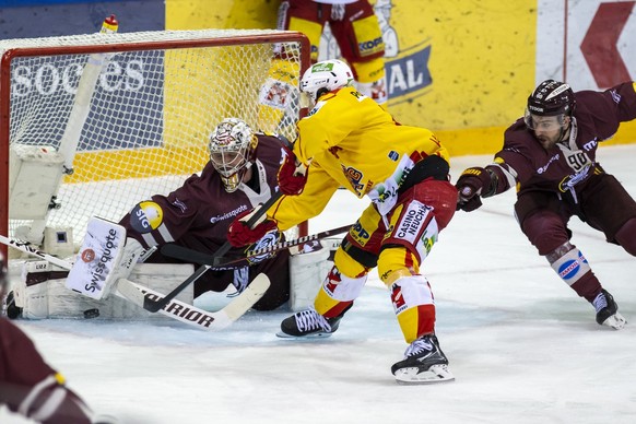 L&#039;attaquant biennois Damien Brunner, centre, lutte pour le puck avec le defenseur genevois Simon Le Coultre, droite, devant le gardien genevois Robert Mayer, gauche, lors du premier match de la f ...
