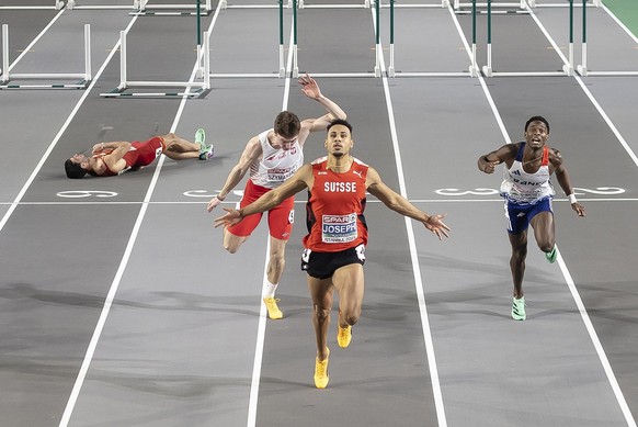 Winner Jason Joseph of Switzerland, center, reacts as Enrique Llopis of Spain, left, lies on the track after he crashed and hit his head on the ground in the Men&#039;s 60 meters hurdles Final at the  ...